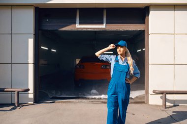 Üniformalı güzel bir kadın çamaşırcı, araba yıkama servisi. Kadın araba, araba yıkama istasyonu, araba yıkama işi.