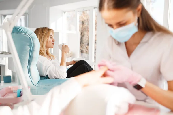 Två Flickvänner Kopplar Pedikyr Procedur Skönhetssalong Professionell Kosmetolog Och Kvinnliga — Stockfoto