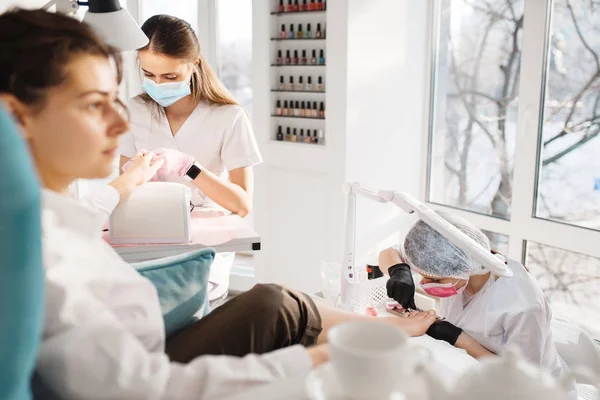 Dos Mujeres Procedimiento Pedicura Salón Belleza Esteticistas Profesionales Clientes Femeninos —  Fotos de Stock