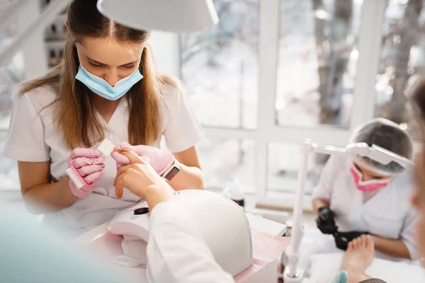 Dois Mestres Pedicure Procedimento Manicura Salão Beleza Esteticistas Profissionais Clientes — Fotografia de Stock