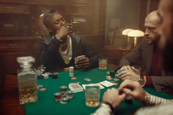 三个扑克牌手坐在赌桌旁 手里拿着绿色的桌布 游戏的机会上瘾 男人喜欢喝威士忌和雪茄 — 图库照片