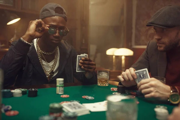 两个纸牌扑克玩家坐在赌桌旁 赌场里铺着绿色的桌布 游戏的机会上瘾 男人喜欢喝威士忌和雪茄 — 图库照片