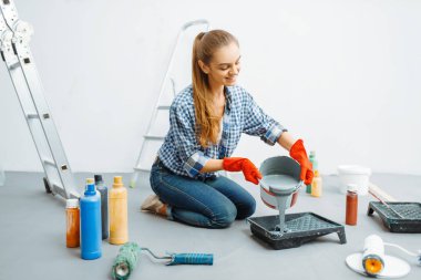 Kadın boyacı iş için hazırlanıyor. Ev onarımı, gülen kadın daire tadilatı, oda dekorasyonu.