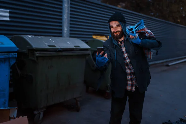 快乐的乞丐在街上的垃圾桶里找到了手机 贫穷是一个社会问题 无家可归 城市孤独 — 图库照片