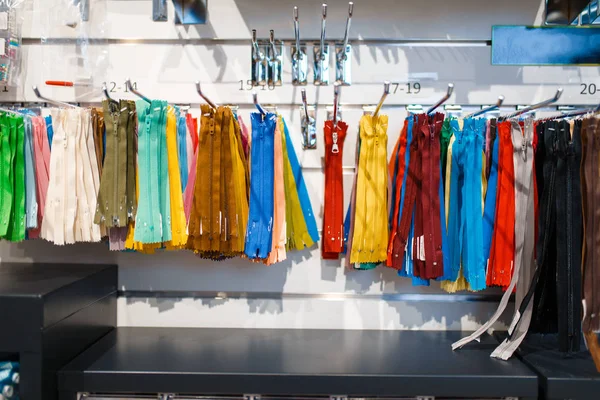 在纺织品商店的货架上挂着五颜六色的拉链 没有人 带有缝纫 服装选择等精品的橱窗 — 图库照片