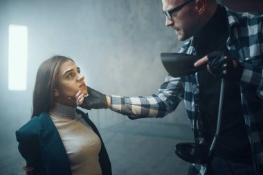 Manyak adam, kurbanının yüzüne fener tutar. Adam kaçırma ciddi bir suçtur. Deli erkek psikopat, adam kaçırma, şiddet.