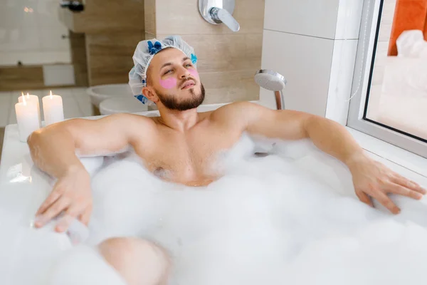 男は顔のマスクを適用し 泡と風呂に横たわっています 朝の衛生 男性はバスルーム 皮膚やボディトリートメントの手順でリラックス — ストック写真