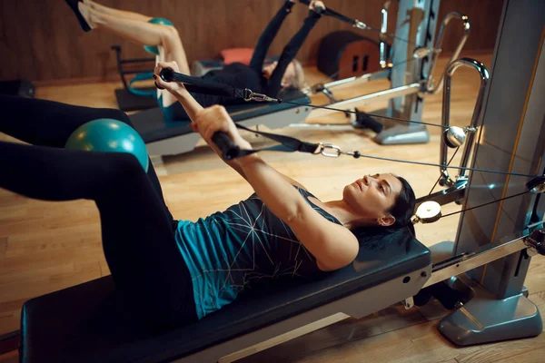 Spor Giyimli Iki Kadın Spor Salonunda Egzersiz Makinelerinde Pilates Eğitimi — Stok fotoğraf