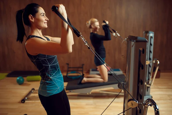 ジムでの運動機械の訓練でピラティスの2人の女性 柔軟性 スポーツクラブでフィットネスワークアウト アスレチック女性 エアロビクス室内 ストレッチボディ — ストック写真