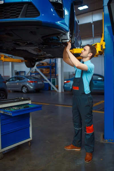 Opravář Uniformě Opravující Vozidlo Výtahu Autoservisní Stanice Kontrola Kontrola Automobilů — Stock fotografie