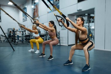 Spor salonunda, arka planda egzersiz yapan bir grup kadın. Spor kulübünde spor yapan insanlar spor giyim kuşamında spor yapan atletik kızlar kapalı alanda antrenman yapıyorlar.