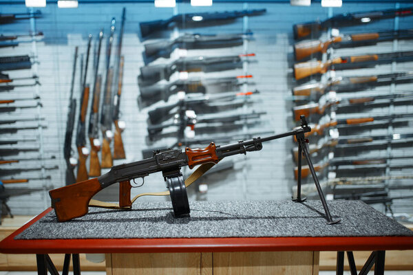 Retro rifle with a drum magazine, showcase in gun shop, nobody. Euqipment for hunters on stand in weapon store, hunting and sport shooting hobby 