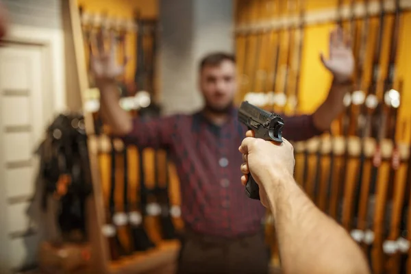 男は銃屋で新しい拳銃の販売を目指しています 武器店の警備のためのピストルを購入男性 自己防衛とスポーツシューティング趣味 — ストック写真