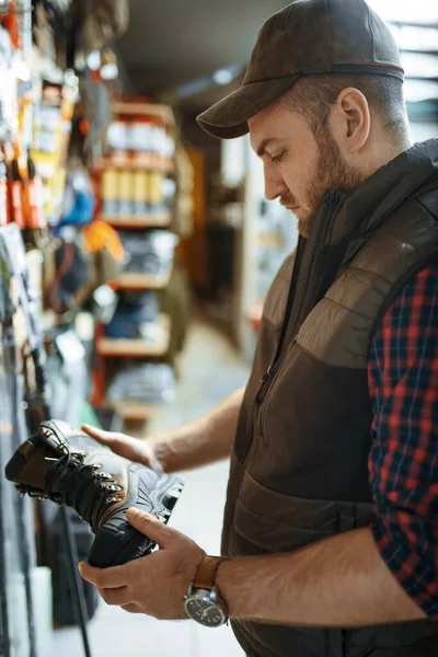 Mann Wählt Stiefel Für Jäger Vitrine Waffengeschäft Euqipment Und Gewehre — Stockfoto