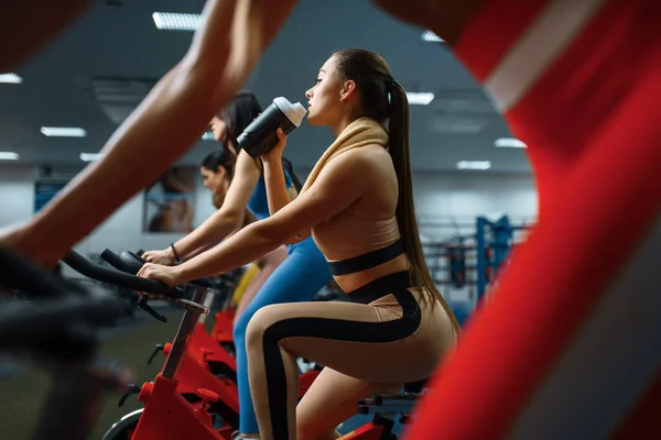 Frau Trinkt Wasser Auf Stationärem Fahrrad Fitnessstudio Menschen Beim Fitnesstraining — Stockfoto