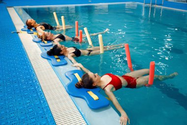 Kadın yüzücüler grubu, havuz başında su aerobiği eğitimi. Sudaki kadınlar, havuzda spor yüzme egzersizleri.