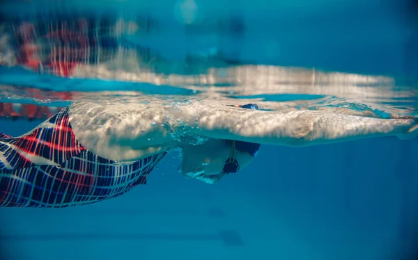 身穿泳衣 戴着帽子 戴着眼镜的女游泳者在游泳池里游泳 俯瞰水下风景 女人在水里屏住呼吸 屏住呼吸技巧练习 — 图库照片