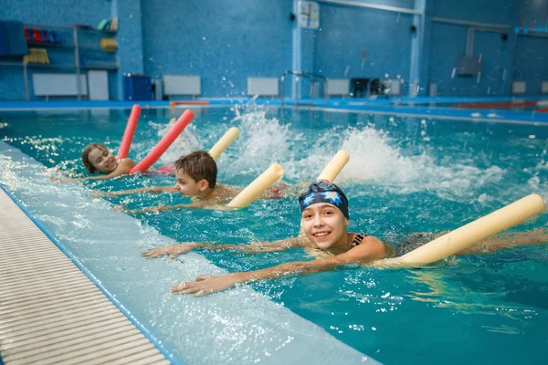 子供たちの水泳グループに戻るには プールでのワークアウトに横たわっている 子供たちは水中で泳いだり スポーツトレーニングをしたり ボードで運動することを学びます — ストック写真