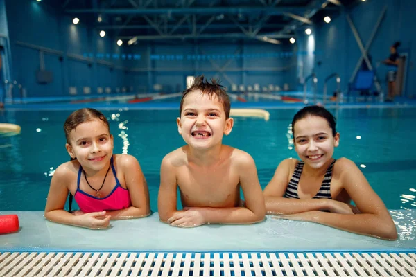 笑顔の子供たちグループはプールサイドでポーズをとり 水泳ワークアウトをします 子供たちは水中で泳ぐこと プールでのスポーツトレーニング 若い水泳を学ぶ — ストック写真