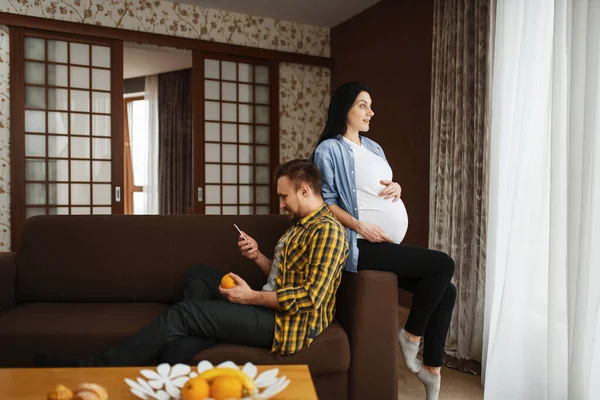 夫と妊娠中の妻は家でリラックスしています 妊娠期間 期待のお母さんとお父さんが休んでいる 健康管理 — ストック写真