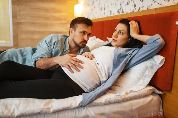 丈夫在家听孩子在怀孕的妻子的肚子里 卧室里有背景 产前时期 预期的妈妈和爸爸都在沙发上休息 医疗保健 — 图库照片