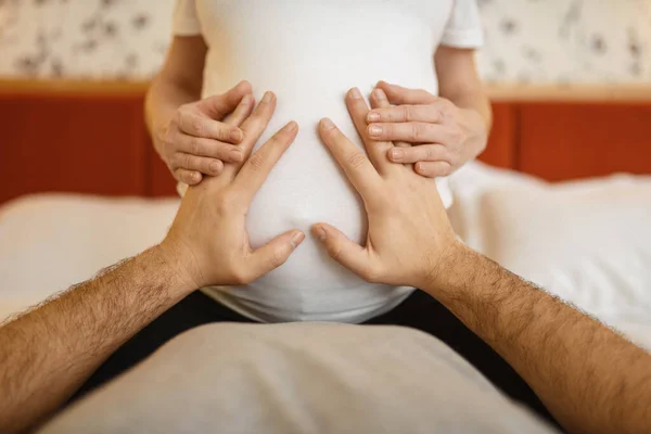 ベッドで幸せなカップル 夫は彼の妊娠中の妻の腹に触れる 妊娠期間 期待のお母さんとお父さんが休んでいる 健康管理 — ストック写真