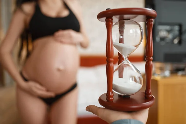 Schwangere Mit Bauch Posiert Hause Gegen Sandglas Seitenansicht Schwangerschaft Ruhe — Stockfoto