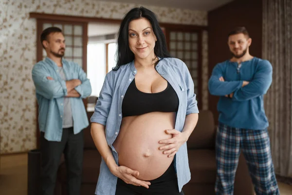 腹を持つ妊婦 背景に2人の男性 誰が父であります ユーモア 自宅で出生前の期間 期待してるお母さん冗談 — ストック写真