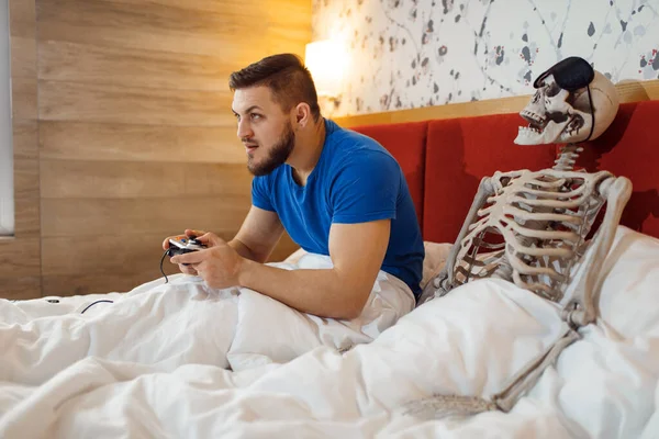 Man Playing Game Console Wife Skeleton Bed Bad Relationship Couple — Stock Photo, Image