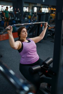 Spor kulübünde egzersiz yapan şişman bir kadın, aktif eğitim. Kadın aşırı kiloyla, obeziteye karşı aerobik egzersizle, spor salonuyla mücadele ediyor.