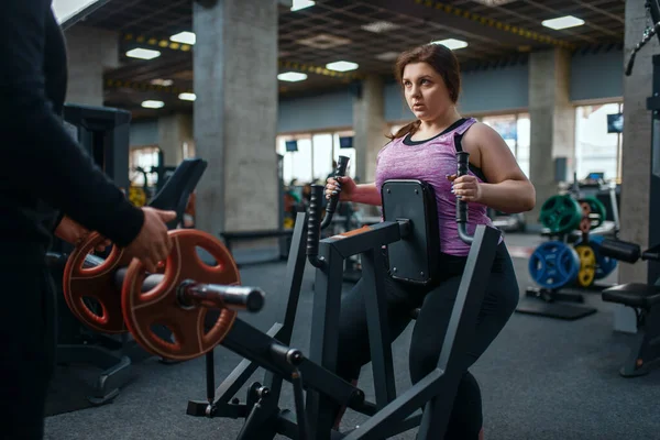 在健身房的运动机器上 超重的女人 和教练一起训练 女性与超重 有氧运动和肥胖作斗争 — 图库照片