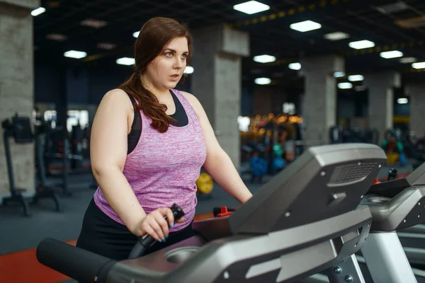 超重的女人在健身房的跑步机上做运动 积极锻炼 肥胖女性与超重 有氧运动 体育俱乐部作斗争 — 图库照片