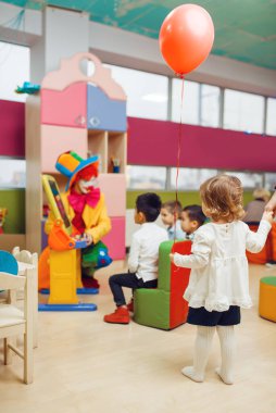 Mutlu çocuklu komik palyaço alfabede oynuyor. Doğum günü partisi oyun odasında, bebek tatili çocuk parkında. Çocukluk mutluluğu, çocuksu bir eğlence.