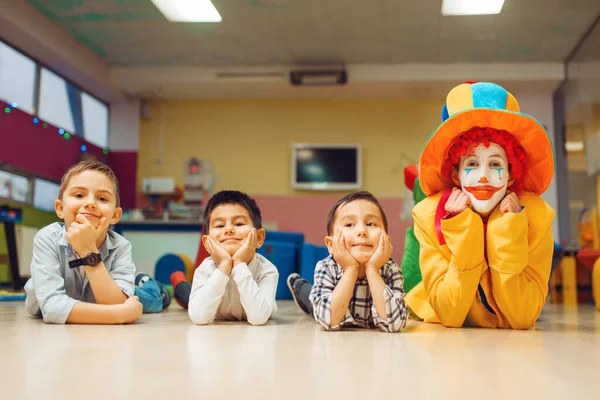 Lustig Clown Och Små Barn Som Ligger Golvet Födelsedagsfest Barnledighet — Stockfoto