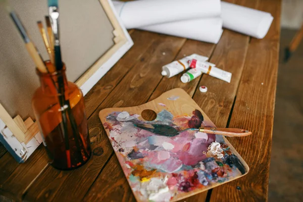 パレットの上の塗料 ボトルのブラシ キャンバス アートスタジオのテーブルの上の画家ツール アーティストの職場の設備 創造的なアトリエやワークショップ — ストック写真