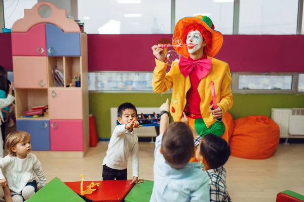 Grappige Clown Met Kinderen Blaast Zeepbellen Bij Elkaar Verjaardagsfeest Vieren — Stockfoto