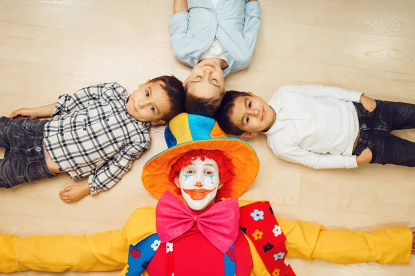 Rolig Clown Och Små Barn Som Ligger Golvet Och Drar — Stockfoto