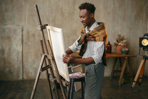 幸せな画家は アートスタジオでキャンバスでイーゼルを準備します 男性アーティストは彼の職場で ワークショップで創造的なマスター作品を描く — ストック写真