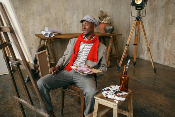 穿着帽子和红围巾的时尚男画家 艺术工作室 画家在他的工作场所画画 在车间里创作大师作品 — 图库照片