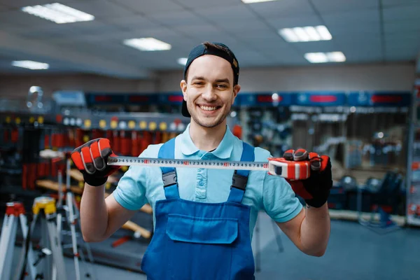 Trabalhador Sexo Masculino Sorridente Uniforme Detém Fita Métrica Loja Ferramentas — Fotografia de Stock