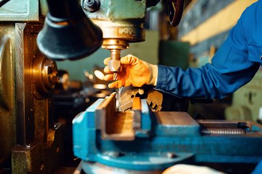 Üniformalı ve kasklı erkek teknisyen torna tezgahında çalışıyor. Endüstriyel üretim, metal mühendisliği
