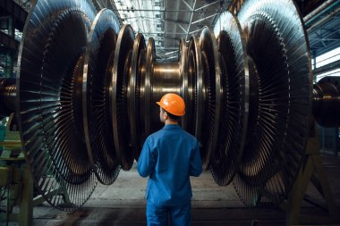 Erkek işçi türbin iticilerini kontrol ediyor. Endüstriyel üretim, metal mühendisliği, güç makineleri üretimi