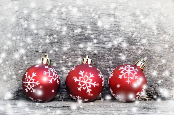 Bolas de Natal sob flocos de neve — Fotografia de Stock