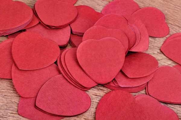 Confeti rojo en forma de corazón sobre una tabla — Foto de Stock