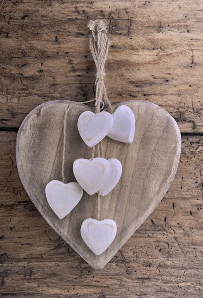 Corações de madeira decorativos na prancha — Fotografia de Stock