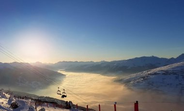 Günbatımında bir vadide bulutların üstünde göster 