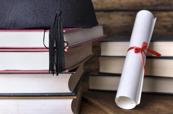 Cappello e dildo con libri accatastati — Foto Stock