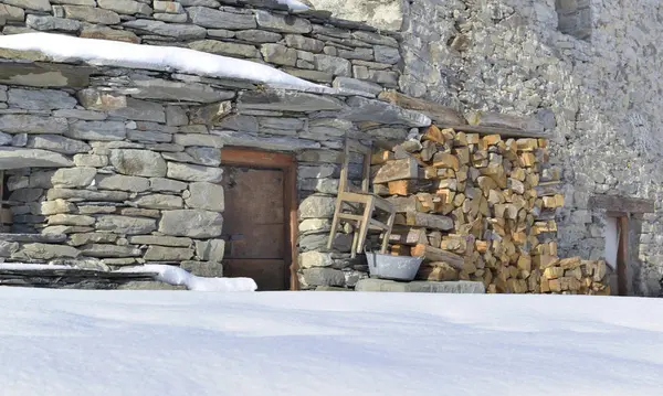 Gevel van een traditioneel alpenhuis gestenigd met brandhout opgestapeld — Stockfoto