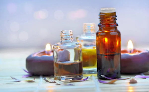 Few bottles of essential oil with light candles Stock Photo