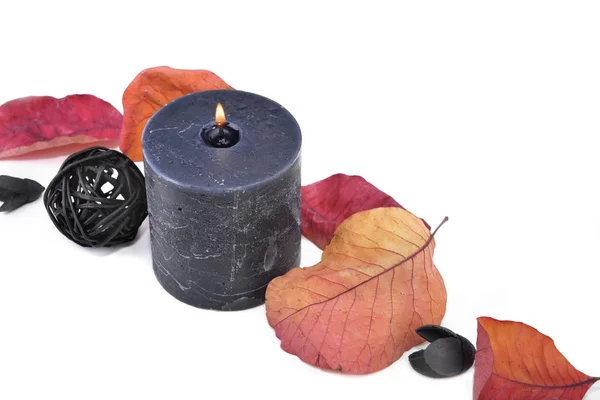 Černé svíčky s podzimním listem na bílém pozadí — Stock fotografie